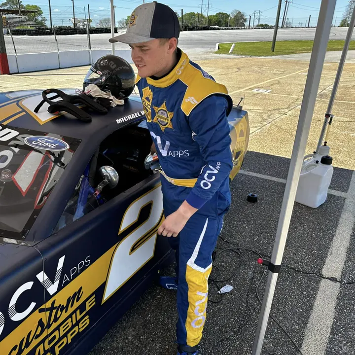 Mike Wood beside his number 2 car in a blue and yellow FervoGear suit Mike Wood beside his number 2 car in a blue and yellow FervoGear suit