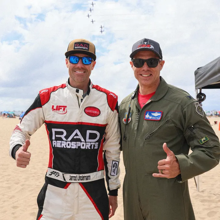 Jarrod Lindemann in a red and white FervoGear suit with a pilot Jarrod Lindemann in a red and white FervoGear suit with a pilot