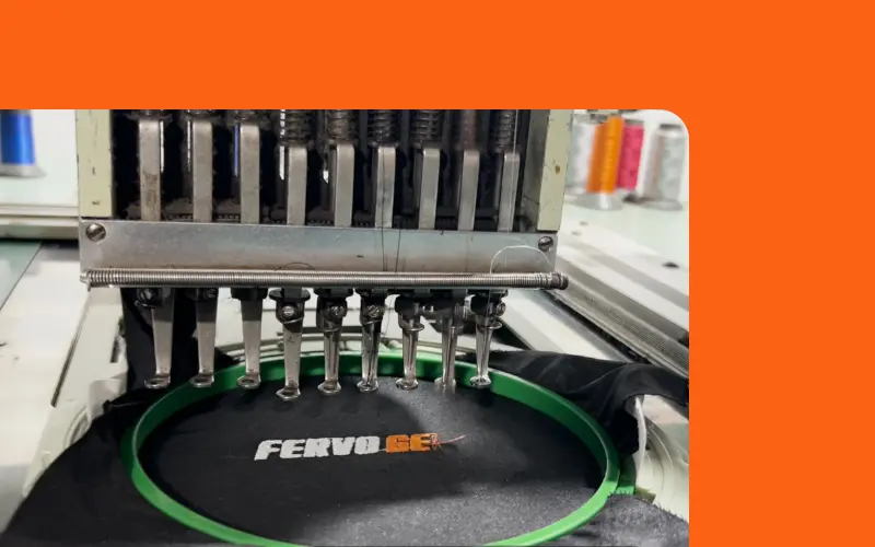 An embroidery machine stitching the FervoGear logo An embroidery machine stitching the FervoGear logo